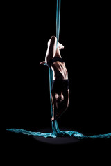 Young woman gymnast with blue gymnastic aerial silks