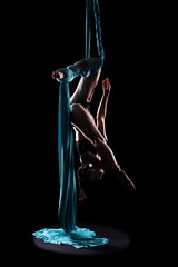 Young woman gymnast with blue gymnastic aerial silks