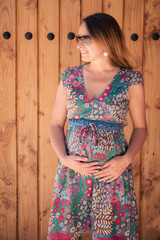 Fototapeta premium Pregnant young woman on a wooden background