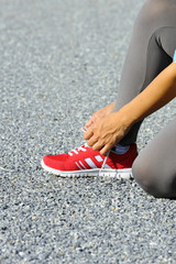 Female hand tying shoelaces.
