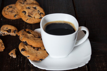 кофе в белой чашке с печеньем на деревянном столе