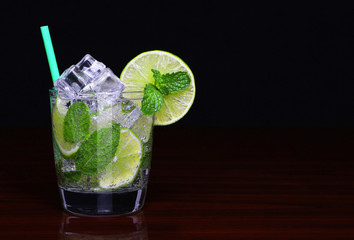 Mojito cocktail in glass with mint over black background