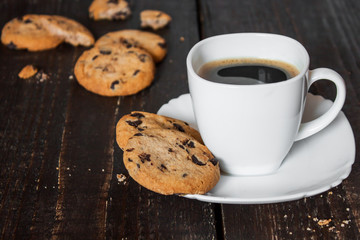 кофе в белой чашке с печеньем на деревянном столе