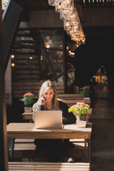 Beautiful woman working on her laptop on a stylish urban restaurant