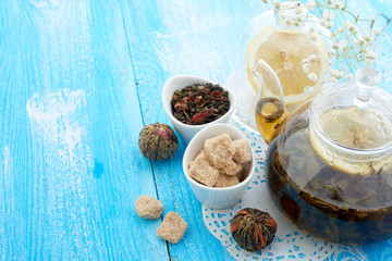 Ripe lemon, cinnamon and fruit drink in glass teapot on wooden