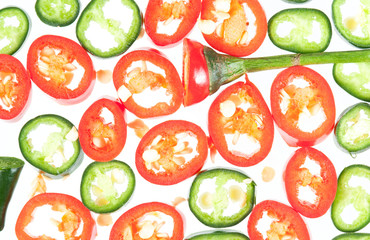 Sliced in pieces red and green chili peppers isolated over white