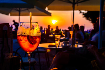 Oranje ijskoude cocktail in een strandbar bij zonsondergang