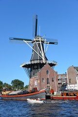 Fototapeta na wymiar Mill in Haarlem with boats