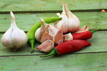 garlic and hot peppers on old wooden background