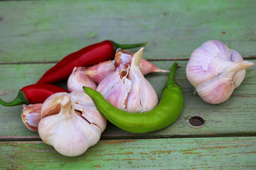 garlic and hot peppers on old wooden background