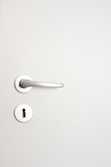 Door handle and keyhole on the white wooden door