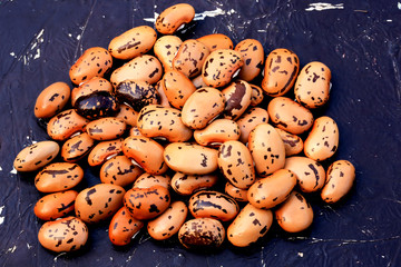 Dry pinto beans on old wooden background