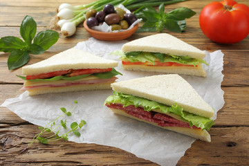 sandwich con salami e verdure sfondo tavolo legno rustico