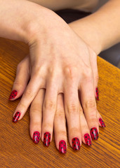 	 Palm of the girl with red nail Polish, on one another.