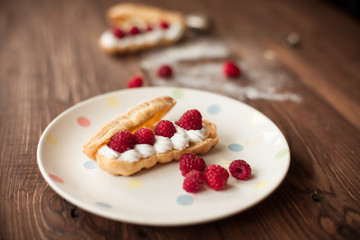Breakfast with sweet eclairs on table
