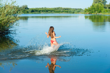 Girl in red bikini run into water