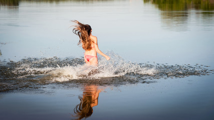 Girl in red bikini run into water
