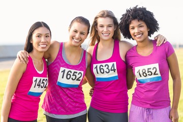 Four smiling runners supporting breast cancer marathon