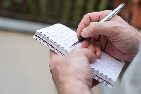 Man Taking Notes On A Pocket Book