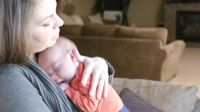 Mother bouncing and patting her newborn son