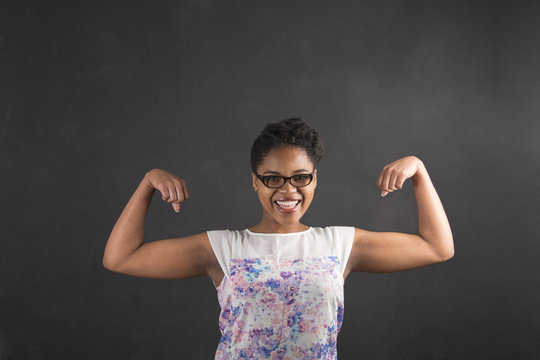 African Woman With Strong Arms On Blackboard Background