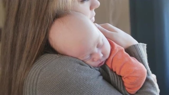 Newborn Baby boy asleep on mother's shoulder