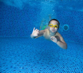 Young Boy Fun in the Swimming Pool with Goggles. Summer Vacation Fun.