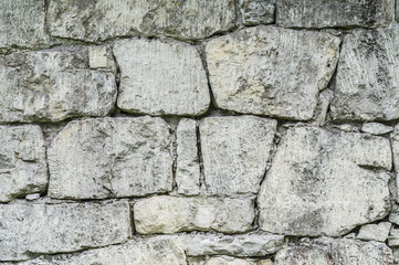Fototapeta premium Stone wall background made up from different sizes of limestones