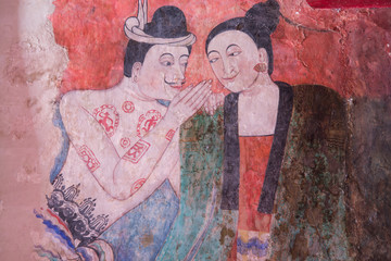Ancient Buddhist temple the famous mural painting of a man whispering to the ear of a woman. at Wat Phumin, a famous temple in Nan province,Thailand. The temple is open to the public.