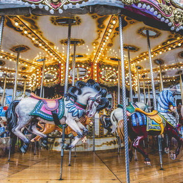 Old French carousel in a holiday park. Three horses and airplane