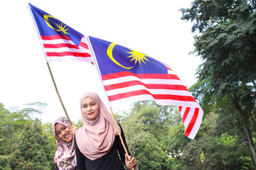 muslim women holding a malaysian flag