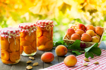 Naklejka premium Jars with preserved apricot and fresh apricot fruit