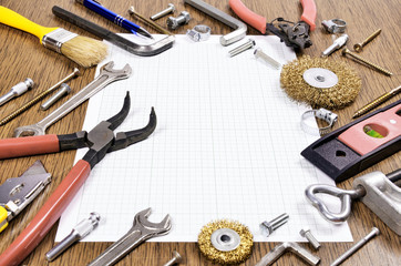 Set of different old Tools and grid paper on wooden background