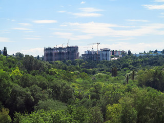 Residential modern apartment house, green forest and blue sky