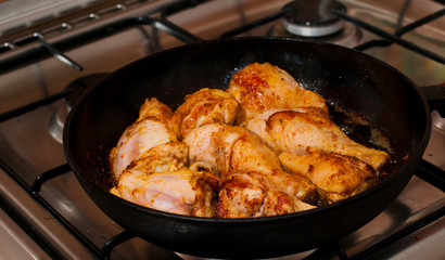 Frying pan with chicken legs inside