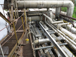 Old rusty industrial steel pipelines, valves and equipment at po