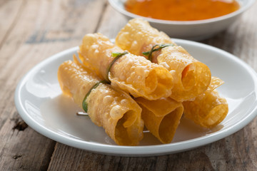 Fried wonton with sauce on wood table.
