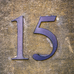 A metal sign with the number fifteen. - 89348795