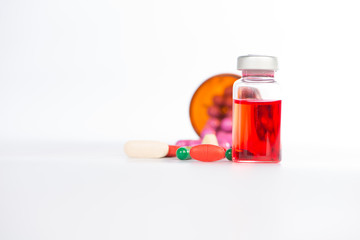 Injection vials and medicine tablet on white