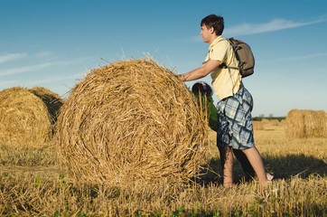 Naklejka na ściany i meble Children roll haystack on the field
