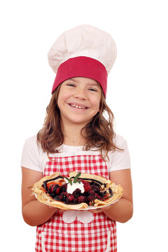 happy little girl cook hold crepes filled with fruits