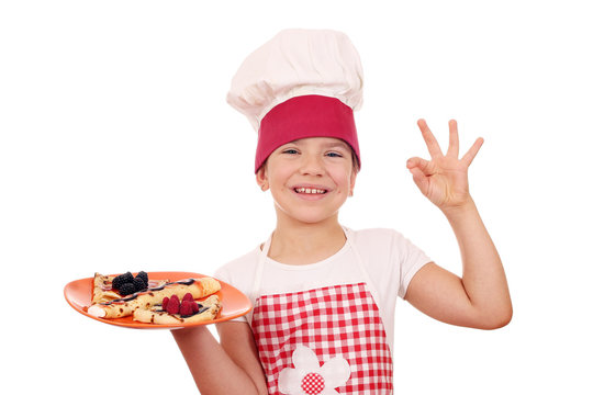 happy little girl cook with crepes and ok hand sign