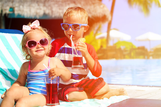 kids relax on tropical beach resort and drink juices