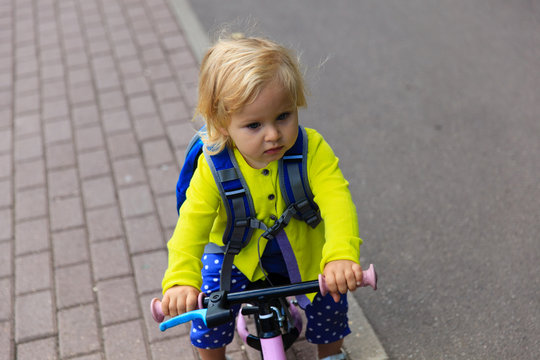 little girl riding runbike outdoors