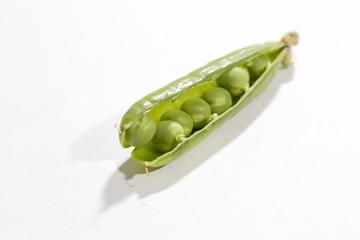 Peas in the open pod. Some of the peas are out of the pod. Image taken in a studio.