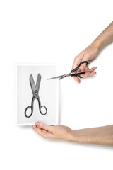 Hand cutting a Photograph of old scissors with modern scissors