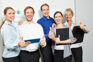 Business Team im Büro hält Daumen hoch