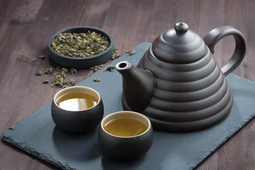 Foto op Aluminium freshly brewed green tea in ceramic ware on wooden table © cook_inspire