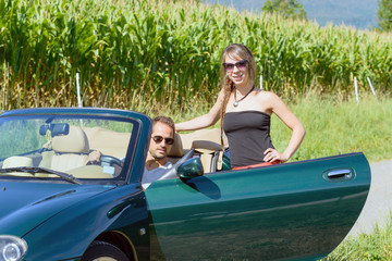 a young couple in a convertible car