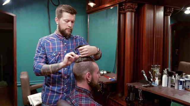 Beard barber making haircut to hipster client